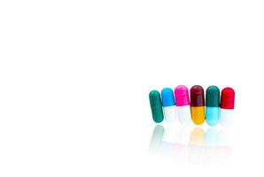 Antibiotic capsules pills in a row on white background with shadows and copy space. Drug resistance concept. Antibiotics drug use with reasonable and global healthcare concept. photo