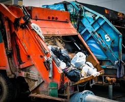 Back of old garbage truck with waste. Urban waste management concept. photo