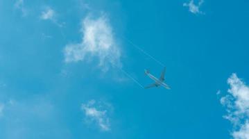 Airplane on blue sky and white clouds. Commercial airline flying on blue sky. Travel flight for vacation. Aviation transport. photo