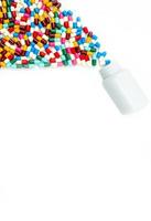 Antibiotic capsules spilling out of pill bottle on white background with copy space, just add your own text. Drug resistance concept. Antibiotics drug use with reasonable and global healthcare concept photo