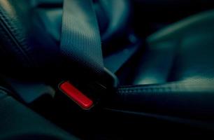 Car seat belt with red press button. Fasten seatbelt for safety and security and protect life from car accident. Buckle up black seat belt for safety. Buckle up seat belt it's the law. Safe road trip. photo