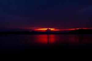 cielo rojo y morado al atardecer en la montaña y el lago. hermoso cielo de la tarde. majestuoso cielo al atardecer. fondo de la naturaleza. imagen artística del cielo al atardecer. fondo abstracto al atardecer. concepto de anochecer y amanecer foto