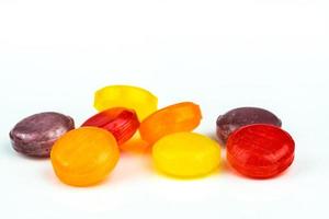 pastillas médicas para aliviar la tos, el dolor de garganta y la irritación de garganta aisladas en fondo blanco. bajan la tos y los resfriados. pastilla para la tos de colores. caramelos o dulces redondos rojos, naranjas, amarillos y morados. foto