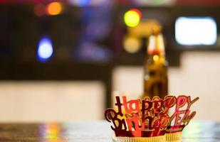 Diadema de feliz año nuevo rojo dorado sobre fondo colorido bokeh foto