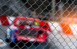 Motorsport car racing on asphalt road. View from the fence mesh netting on blurred car on racetrack background. Super racing car on street circuit. Automotive industry concept. photo