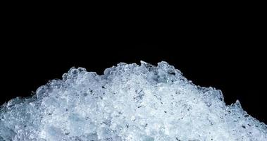 Pile of crushed ice cubes on dark background with copy space. Crushed ice cubes foreground for beverages. photo