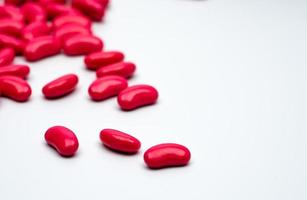 Red kidney shape sugar coated tablet pills isolated on white background with copy space for text. photo