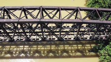 Aerial dolly move left and look down steel railway bridge at river video