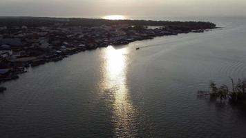 bateau et village au coucher du soleil video