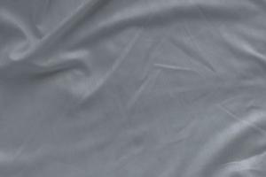 textura de sábana de lino blanco en la habitación del hotel. detalle de primer plano de la sábana blanca desordenada. cómoda cama con sábanas a prueba de ácaros del polvo doméstico. concepto de hogar de ropa de cama. Tejido de microfibra a prueba de alérgenos. foto