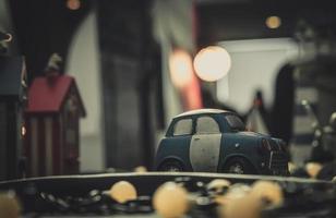 Blue and white small car toy model on the road. Mini car toy in the city near building on blurred background with bokeh. Cartoon miniature car. World of imagination. Romantic dating night. photo