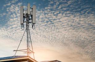 Telecommunication tower with blue sky and white clouds background. Antenna on blue sky. Radio and satellite pole. Communication technology. Telecommunication industry. Mobile or telecom 4g network. photo