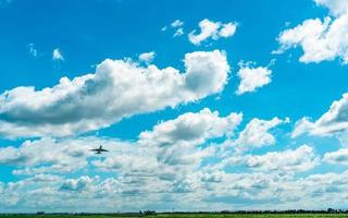 aerolínea comercial volando sobre cielo azul y nubes blancas esponjosas. avión de pasajeros después de despegar o ir al vuelo de aterrizaje. viajes de vacaciones al extranjero. transporte aéreo. área alrededor del aeropuerto. foto