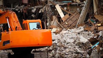 Destroyed building industrial. Building demolition by explosion. Abandoned concrete building with rubble and scrap. Earthquake ruin. Damaged or collapsed building from hurricane disaster. Backhoe. photo