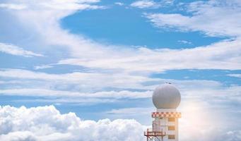 Weather observations radar dome station against blue sky and white fluffy clouds. Aeronautical meteorological observations station tower use for safety aircraft in aviation business. Spherical tower. photo