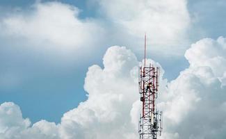 torre de telecomunicaciones con cielo azul y nubes blancas. trabajador instaló equipo 5g en torre de telecomunicaciones. tecnología de comunicación. industria de las telecomunicaciones Red móvil o de telecomunicaciones 5g.