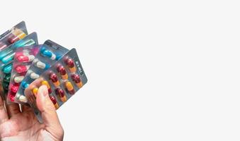 People hand holding pack of antibiotic capsule pills isolated on white background. Giving or receiving drug. Antibiotic drug overuse. Antimicrobial drug resistance. Pharmaceutical product. Healthcare. photo