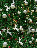 cierra la decoración del árbol de navidad con bolas rojas, doradas, plateadas y blancas, estrella plateada y reno blanco. fondo de navidad. fondo de navidad y feliz año nuevo. bola de colores en el árbol de navidad. foto