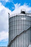 Agricultural silo at feed mill factory. Big tank for store grain in feed manufacturing. Seed stock tower for animal feed production. Commercial feed for livestock, swine and fish industries. photo