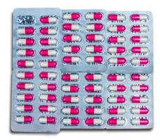 Top view of colorful antibiotic capsules pills in blister packs isolated on white background. Global health care and drug use with reasonable concept. Pink-white antimicrobial capsule pills. photo