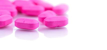 Pink tablets pills on white background. Pharmaceutical industry. Pharmaceutical production. Painkiller medicine. Ibuprofen pink tablets pills for migraine headache and anti-inflammatory. NSAIDs drug. photo