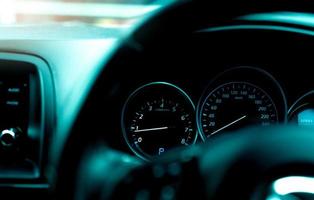 vista interior del salpicadero del coche. panel de instrumentos del coche con tacómetro y velocímetro. vista desde el volante hasta el indicador de rpm y el medidor de velocidad. indicador de motor de coche. tablero de instrumentos de primer plano con luz automática. foto