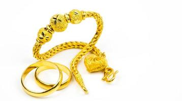 pulsera de joyería de oro de estilo tailandés y anillo de oro de pareja aislado en fondo blanco con espacio de copia, solo agregue su propio texto. regalo de año nuevo chino. concepto de negocio de tienda de oro foto