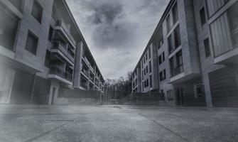 Empty road between residential building with dark clouds and sky in the city. No people on urban street. Real estate and property crisis impact of coronavirus. The real estate market is sluggish. photo