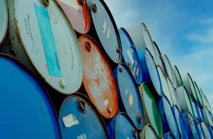 Old chemical barrels stack. Blue and red oil drum. Steel oil tank. Toxic waste warehouse. Hazard chemical barrel. Industrial waste in tank. Hazardous waste. Rusty oil drum stack. Brent crude oil. photo