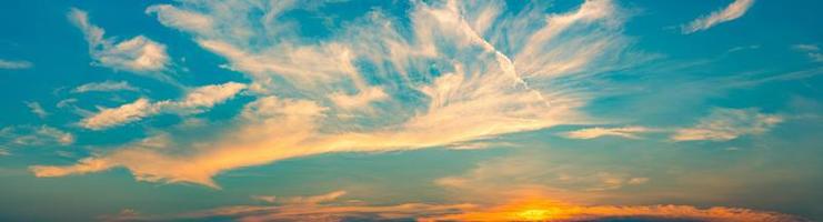 Beautiful blue and golden sky and clouds abstract background. White and golden clouds on sunset sky. Warm weather background. Art picture of sky at sunset. Sunset and fluffy clouds for inspiration. photo