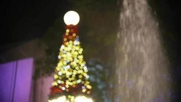 kerstboom knippert naast fontein. video