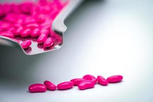 Me encantan las vitaminas para el concepto del día de San Valentín. pastillas de color rosa en la bandeja de medicamentos de acero inoxidable. foto