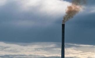 contaminación del aire de la fábrica. humo de la chimenea de la tubería industrial en el cielo del atardecer. concepto de problema de calentamiento global. mala calidad del aire. factores de emisión de contaminantes atmosféricos. contaminación del aire pm 2.5 polvo. foto