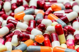 Pile of antibiotic capsule pills. Antibiotic drug resistance. Capsule pills for treatment infection disease. Antibiotic drug use with reasonable. Pharmaceutical industry. Pharmaceutics background. photo