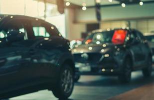 Blurred SUV car parked in luxury showroom. Car dealership office. New car parked in modern showroom. Car for sale and rent business. Automobile leasing and insurance background. Automotive industry. photo