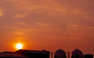 Industrial gas storage tank. LNG or liquefied natural gas storage tank. Red and orange sunset sky. Spherical gas tank in petroleum refinery. Above-ground storage tank. Natural gas storage industry. photo