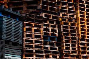 Pile of old wooden pallet. Industrial wood pallet stacked at factory warehouse. Cargo and shipping concept. Wood pallet rack for export delivery industry. Wooden pallet storage warehouse of factory. photo