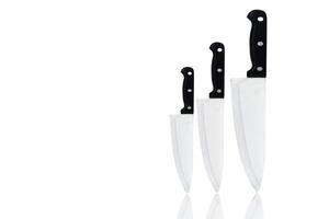 Set of new sharp chef knives with black handle isolated on white background. Stainless steel knife for home cook or for chef in restaurant kitchen. Butcher knife for carving food. Utensil in kitchen. photo
