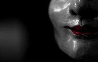 Statue face of woman made of plaster. Statue face of woman on dark background. Sculpture art. Statue face of woman looking for something. Red lips. photo