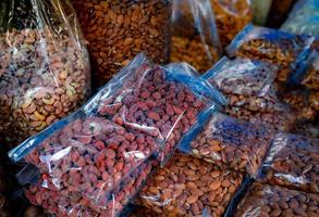 almendras y anacardos en bolsa de plástico en el mercado. comida sana. alimentos ricos en proteínas para fitness o personas en ayunas intermitentes. semilla pelada. refrigerio saludable. nueces crudas para asar. comida vegana en paquete. foto