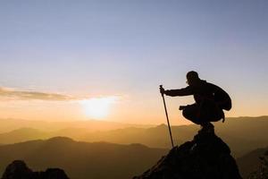 silueta de mujer escaladora en la cima de la montaña, trekking, éxito, competencia y concepto de líder. foto