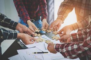 Group of business people assemble jigsaw puzzles, concepts of cooperation, teamwork, help and support in business, symbol of association and connection. business strategy. photo