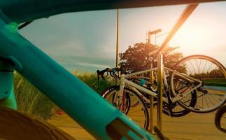 Bicycle parked on aluminium rack at the park. Outdoor exercise and recreation activity. Bicycle at bike parking station. Eco-friendly. Healthy lifestyle. Outdoor activity in summer. Extreme sport. photo