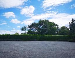 Parking lot sprinkled with gravel on tree bush nature background photo