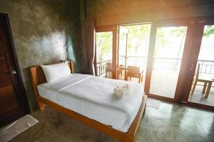diseño de interiores de dormitorio cama blanca y de madera - dormitorio matutino con luz solar y vistas a la naturaleza en la ventana, habitación tipo loft foto