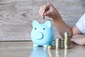 Child woman hand hold pink piggy bank for saving money for education study or investment , Save money concept photo