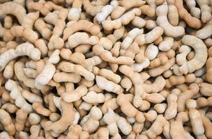 Pile of sweet tamarind for sale in the market fruit - fresh tamarind texture background photo