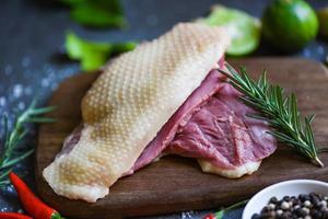 Fresh duck meat for food, Raw duck breast with herb spices ready to cook on wooden cutting board