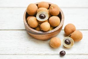 dimocarpus longan frutas exóticas sobre fondo de cuenco de madera - fruta tropical longan fresca en tailandia foto