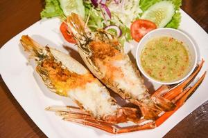 Grilled shrimp cut half with fresh vegetable and seafood sauce, Giant river prawn shrimp grilled serve on white plate photo